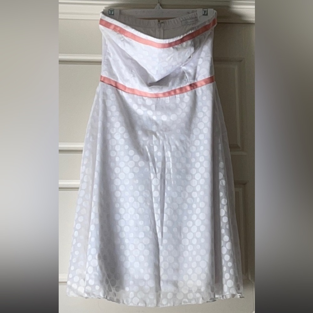 White on white polka dot dress with pink ribbon around waist